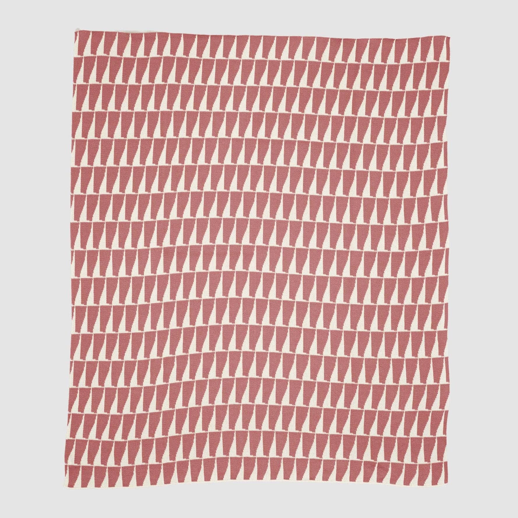 Blanket with pattern of rose-colored triangles on a white background.