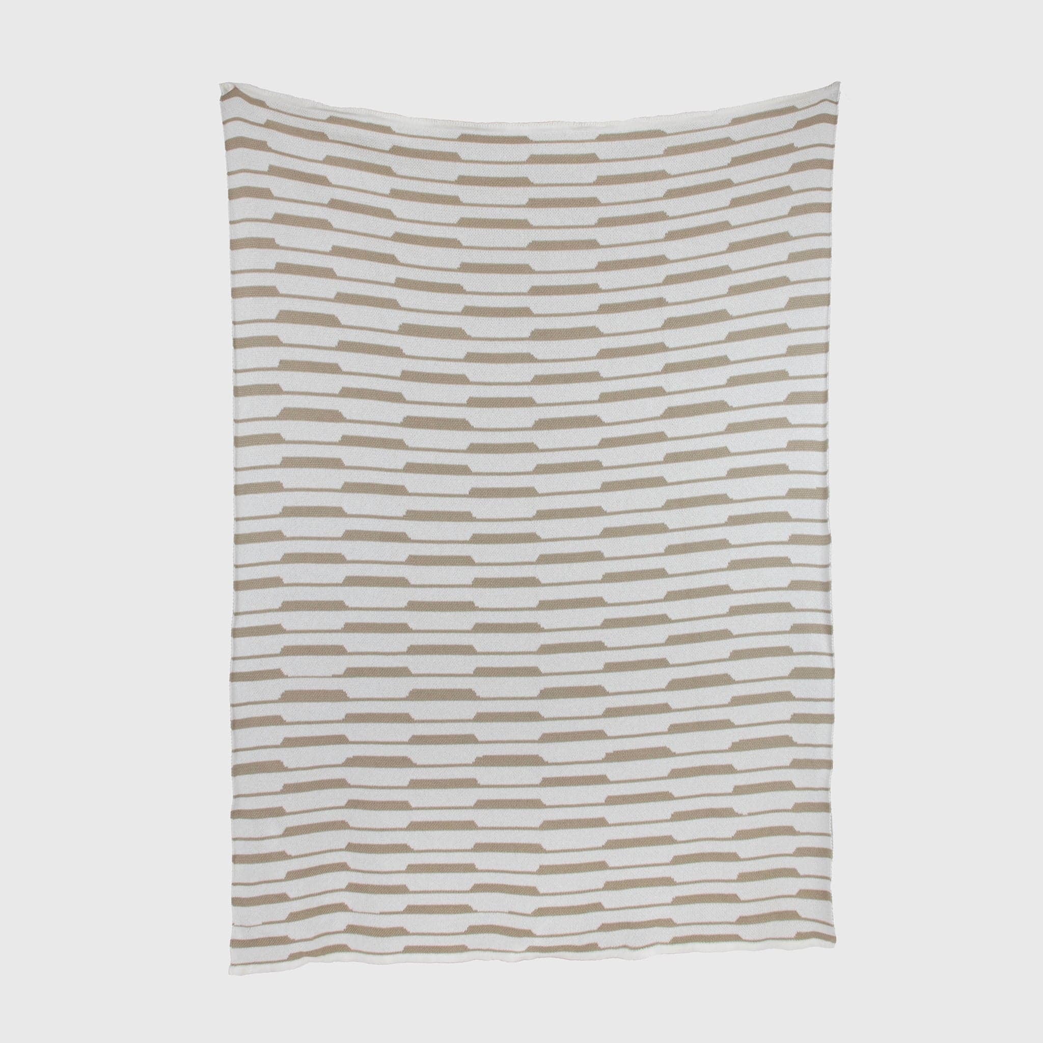 The Riata Throw Blanket by Petra Kaksonen is a rectangular white blanket with staggered rows of beige rectangles, inspired by Scandinavian heritage.