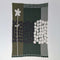 Rock Rose by Susy Pilgrim Waters for In2Green is a modern rectangular textile with a white abstract flower and black-and-white geometric circles on green, black, and white backgrounds, crafted from a sustainable cotton blend.