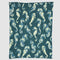 The In2Green Seahorse Watercolor Throw Blanket features yellow and blue seahorses in an aquatic design, repeating across a dark teal background.