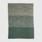 The in2green Textured Ombre Throw Blanket features three horizontal color blocks in green and gray with a subtle ribbed texture on a plain background.
