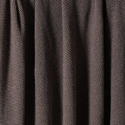 A close-up of the in2green Wool Cardigan Throw Blanket, featuring brown washable wool fabric with vertical folds and a small, repeating square pattern.