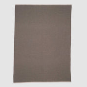 The in2green 100% Merino Wool Links Throw Blanket, shown flat on a white background, features subtle light edges and delivers minimalist elegance in a simple rectangular design.