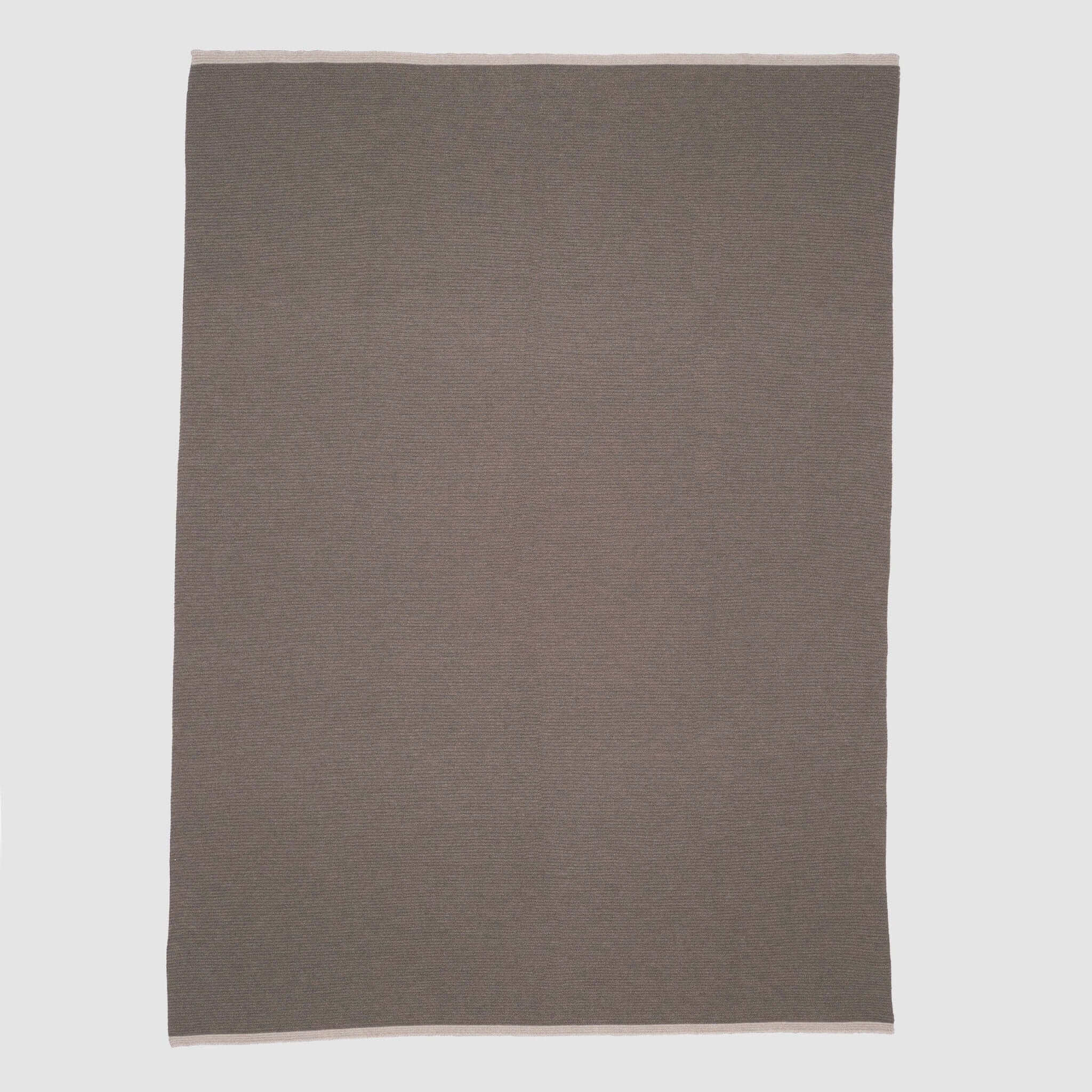 The in2green 100% Merino Wool Links Throw Blanket, shown flat on a white background, features subtle light edges and delivers minimalist elegance in a simple rectangular design.