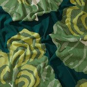 Close-up of the Floréal 7 Throw Blanket by E.A. Seguy for in2green, showcasing bold green and yellow colors with an Art Nouveau-inspired floral design and visible folds.