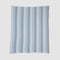 The Herringbone Hues Throw Blanket by In2Green is crafted in the USA from recycled cotton. Featuring alternating light and dark blue herringbone stripes on a white background, it combines style and sustainability for any setting.
