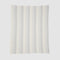 The Herringbone Hues Throw Blanket from In2Green, made in the USA with recycled cotton, features a rectangular design with alternating vertical stripes in light gray and off-white against a plain background.