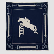 The in2green Equestrian Jumper Throw Blanket features a white silhouette of a horse and rider jumping over a hurdle, elegantly framed by horse bit designs.