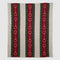 Part of the in2green equestrian collection, the Striped Horse Bit Throw Blanket is a recycled cotton square featuring vertical red, green, and beige stripes with gold horse bit accents along the red stripes.