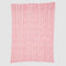 Introducing the In2Green Warrior Throw Blanket Pink: a cozy knitted blanket featuring a pink and white herringbone pattern. Designed for comfort, it offers warmth and support during chemotherapy sessions, symbolizing hope for breast cancer warriors.