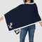 Someone is channeling maritime chic with the Nautical Anchor Poncho by in2green, a navy blue garment featuring a white eco-friendly nautical anchor design. Crafted from recycled cotton, it complements blue jeans beautifully against a crisp white backdrop.